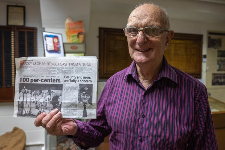 Frank holds up an old newspaper featuring a story on him